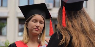 两个年轻的女毕业生在毕业典礼后讨论未来的计划