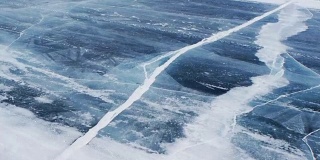 风吹着雪粒在贝加尔湖结冰的水面上移动