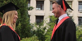 毕业典礼上，最好的朋友们穿着学位服，戴着学位帽，拥抱着，微笑着