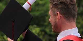 41、快乐的男毕业生戴着学位帽微笑着，毕业典礼上