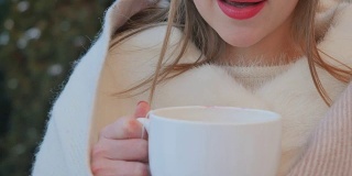 红唇少女冬天在户外喝热茶取暖