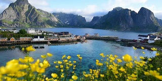 挪威罗浮敦群岛的一个渔村。壮观的晚霞在陡峭的山峰上移动。