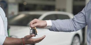在汽车经销店，推销员把钥匙交给一位顾客