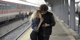 一名年轻男子到达火车站时，发现女友急着要见他，正在用智能手机自拍