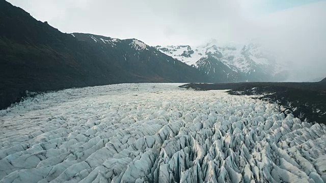 美丽的Vatnajokull冰川与火山灰鸟瞰图。一架直升机飞过冰岛国家公园的冰山