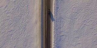 越野车行驶在雪地上。从四轴飞行器鸟瞰雪地和道路。雪地和道路鸟瞰图