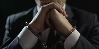 心烦意乱的手铐男子因金融犯罪而入狱，因严重欺诈而受到惩罚