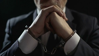 心烦意乱的手铐男子因金融犯罪而入狱，因严重欺诈而受到惩罚视频素材模板下载