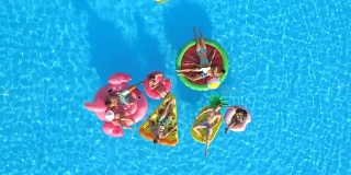 航拍:快乐的人们在游泳池里玩充气球