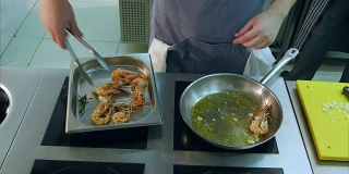 厨师的手把炸虾从锅里移到一个特殊的盘子里