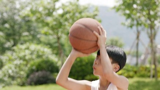 亚洲小孩在户外打篮球的慢动作视频素材模板下载