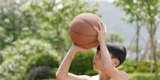 亚洲小孩在户外打篮球的慢动作