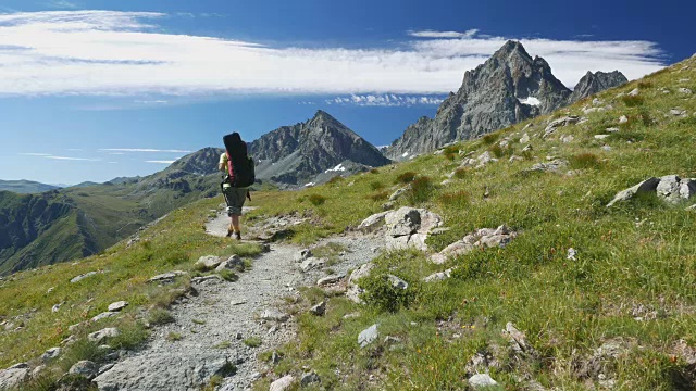 在意大利阿尔卑斯山田园诗般的山景中徒步旅行的女人，慢镜头