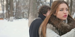 漂亮女人和可爱男人在下雪的冬季公园里争吵