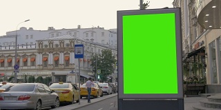 繁忙街道上的一个绿屏广告牌。