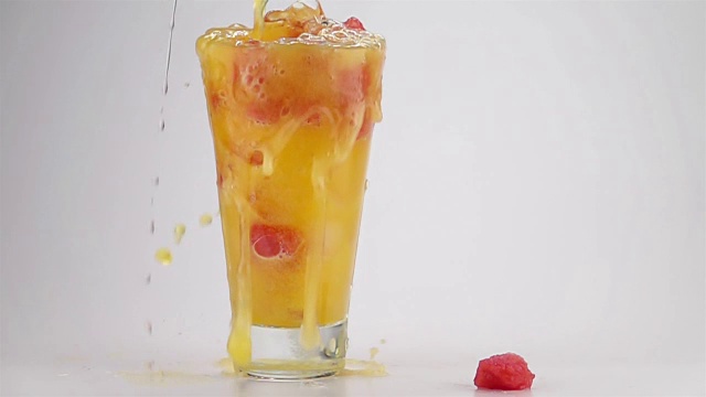 将橘子汽水与冰块和西瓜方块倒入玻璃杯中