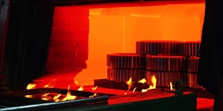 机器零件在炉内高温淬火。大型钢铁厂。金属厂滚
