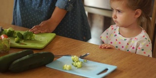 妈妈给了女儿一个柠檬番茄。女孩把蔬菜推开。婴儿食品。健康的生活方式。幼稚的突发奇想。