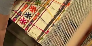 在织布机上织地毯的女人。手工制作的地毯
