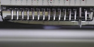工业绣花设备。纺织绣花机在服装制造商。