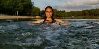 15岁的少女在湖里游泳和戏水。