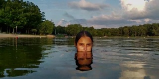 15岁的少女在湖里游泳和戏水。