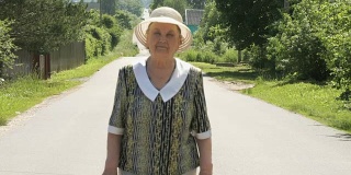 一位老妇人走在村里的路上