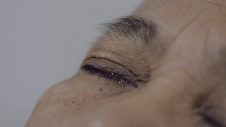 老女人滴了一滴眼药水到眼睛里视频素材模板下载