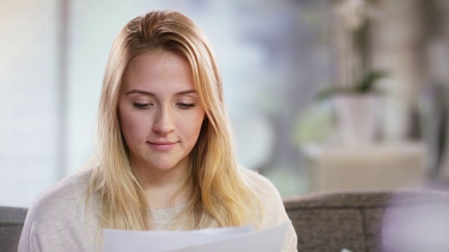 一个微笑的年轻女子读一封信的肖像