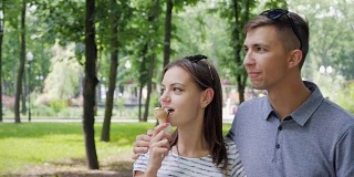 一对恩爱的情侣在公园里吃冰淇淋