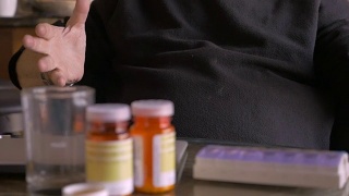 一名沮丧的资深男子在药瓶前慢镜头讲话视频素材模板下载