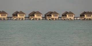 在马尔代夫日出或日落与豪华水上别墅热带泻湖的观点