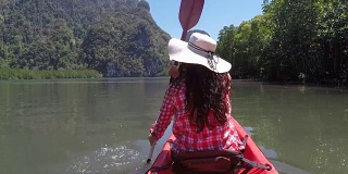 女人划着皮划艇在美丽的泻湖行动摄像POV女孩坐在皮划艇上