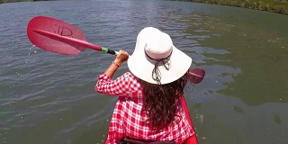 女人划着皮划艇在美丽的泻湖行动摄像POV女孩坐在皮划艇上