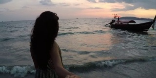 年轻女人在海滩上的男主角在日落行动摄影机点的幸福微笑的女孩在海边的Vew