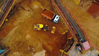 挖掘机装载机在自卸车中装载沙子。鸟瞰图。砂工作视频素材模板下载