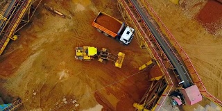 挖掘机装载机在自卸车中装载沙子。鸟瞰图。砂工作