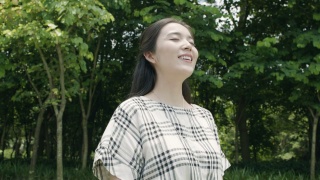 美丽的亚洲女人深呼吸，微笑和享受户外的自然视频素材模板下载