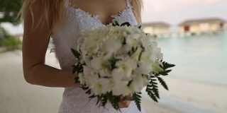 初见新婚夫妇。新娘在一个浪漫的热带小岛上，在蔚蓝的泻湖海洋附近的白色沙滩上举行婚礼