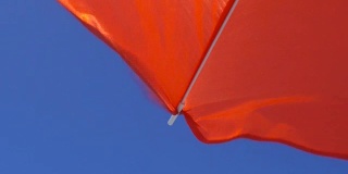 在一个刮风的日子里，意大利地中海海湾的白色沙滩上的太阳伞