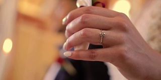在教堂里，新娘手拿戒指和蜡烛