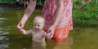 妈妈在池塘里给婴儿洗澡