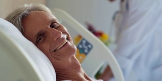 一个快乐的退休老人躺在医院的病床上