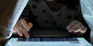中国日报网2015-05-17 09:25晚上，女人在卧室里用手触摸平板电脑