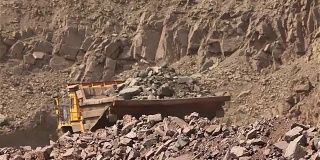 A dumper rides along the road, Yellow dump truck is in the quarry, Industrial exterior