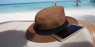 草帽智能手机在马尔代夫海洋海洋。假日放松抽象背景