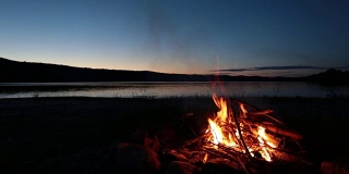 夏日篝火和日落时分的湖泊
