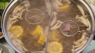 火锅概念的亚洲美食。蘑菇和玉米肉汤。用漏勺煮肉。近距离视频素材模板下载