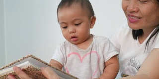 亚洲宝宝和妈妈一起玩和看书