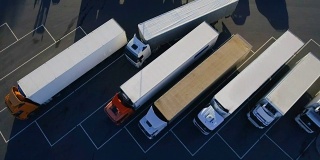 空中鸟瞰图的白色半挂车与其他卡车的货物拖车停车场在特殊停车场。